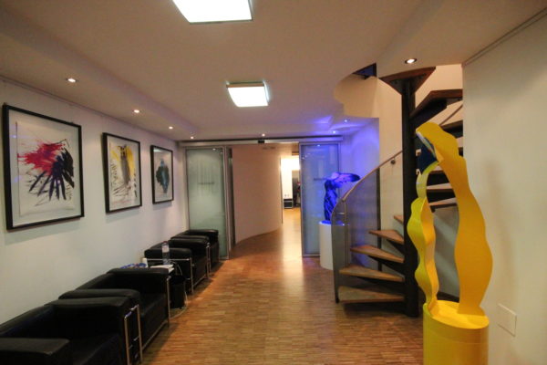 Beleuchteter Flur mit Treppenbereich nach Elektroinstallation durch SHI Elektrotechnik im Rahmen einer Praxis- oder Gewerbesanierung.