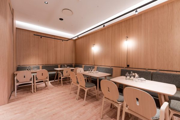 Separater Gastraum mit moderner Lichtinstallation und Holzwänden im Hotel Zeller’s Quartier Königsbrunn, umgesetzt von SHI Gebäudetechnik GmbH