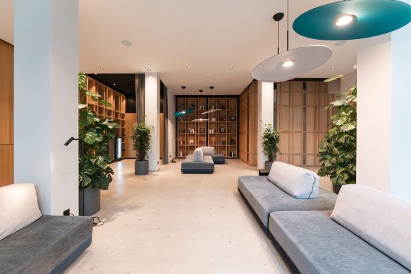 Moderne Lobby mit Designbeleuchtung, Loungemöbeln und Bücherregal im Hotel Zeller’s