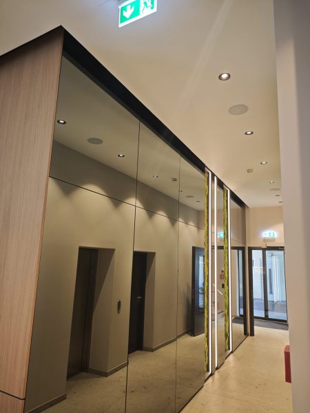 Flur im Hotel Zeller Königsbrunn mit Spiegelwand, Moosbild, indirekter Beleuchtung und Notbeleuchtung von SHI Gebäudetechnik